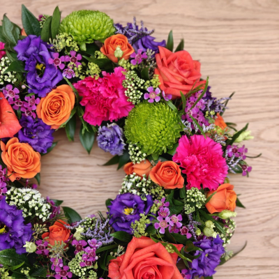 Vibrant wreath - A simple, elegant circular wreath in vibrant shades. 

This funeral tribute will be made with the florist's choice of seasonal flowers and foliage. 

Please note that the sizing is as follows – standard is approximately 12" diameter, medium price is 14" , large option is 16" and extra large is 18". Please note that smaller and larger sizes are available, please contact the shop to order these alternatives. For more information regarding funeral flowers Bolton or funeral flowers Horwich, please call the shop team on 01204 697924 or email us at info@flowersmiths.org.uk. Please note that we need at least 3 days notice prior to the funeral date when ordering this item. For any last-minute orders, please contact us directly before placing the order online. Flowers and foliage will also vary from the photograph depending on seasonal availability.